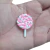 Aplique em formato de pirulito espiral nas cores rosa e branco