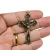 Pingente de cruz com figura de Cristo em metal com acabamento em ouro velho