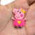 Aplique emborrachado da Peppa Pig, personagem infantil, usando um vestido rosa com um coração.