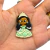 Aplique emborrachado da Princesa Tiana segurado na palma da mão, com vestido verde claro e coroa.
