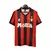 Camisa retrô do AC Milan da temporada 1993/1994, nas cores vermelha e preta, com detalhes em verde e logo da Lotto.