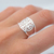 Anillo de plata con diseño de San Benito, mostrado en un dedo.