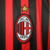 Emblema da camisa AC Milan 2011, destacando as cores vermelha e preta, com a estrela acima.