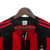 Camisa retro do Milan de 2003, nas cores vermelho e preto, com detalhes em preto e etiqueta da Adidas.
