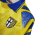Detalhe da camisa retrô amarela do Parma Calcio 1995-96, destacando o escudo e o colarinho azul.