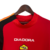 Camisa vermelha da AS Roma 2004, com detalhes em preto e laranja, e logotipo da Diadora.