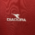 Logotipo da marca Diadora em uma camisa vinho da AS Roma de 1998.