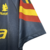 Detalhe da manga da camisa retro azul da AS Roma de 1991, com listras vermelha e amarelo.