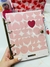 Caderno argolado com capa transparente e design de corações em tons de rosa.