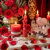 Vela de casal Alma Gêmea vermelha acesa em altar ritualístico com adaga dourada, vaso de rosas vermelhas, vela grossa e cristais de quartzo rosa para amarração amorosa da loja 7 Folhas.