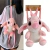 Mochila de pelúcia Lilo & Stitch com alças ajustáveis, na cor rosa, pendurada nas costas de uma pessoa.