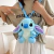 Mochila de pelúcia Lilo & Stitch na cor azul, com alças ajustáveis, sendo usada por uma pessoa.