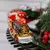 Trem natalino decorativo em movimento, com detalhes em dourado e luzes, ideal para enfeitar árvores de Natal.