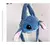 Bolsa mochila em formato de pelúcia do personagem Stitch, com orelhas grandes e olhos azuis, pendurada em um suporte branco.