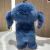 Boneco Stitch de pelúcia azul com orelhas grandes, visto de costas.
