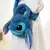 Bolsa mochila do Lilo e Stitch em pelúcia, com detalhes em azul e o rosto do Stitch em destaque.