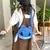 Bolsa mochila pelúcia do Stitch, com alças azuis, sendo usada por uma pessoa.