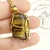RELICARIO DE ACERO RED OJO DE TIGRE DORADO - Ser Mineral Accesorios