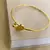 Bracelete de aço inox / Banho dourado, Coração vazado e bolinha.