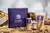 Kit Levide Cosméticos Naturais de Hidratante Iluminador com caixa roxa, frasco com dosador, tubo pequeno e sachê de refil em tom dourado