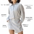 Chemise curta de linho com manga longa, fechamento por botões, com bolsos frontais e traseiros e gola de camisa, com passantes para cinto, comprimento curto e detalhe assimétrico na saia na cor cinza.