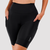 Modelo feminina usando bermuda de corrida de compressão na cor preta, com bolsos laterais e logo da marca Triway.