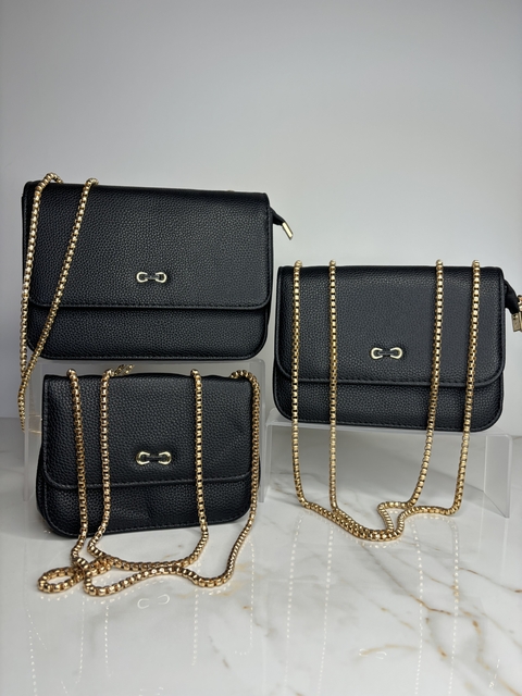 Conjunto de três bolsas pretas com detalhes em dourado, exibidas em uma superfície clara.
