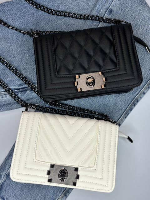 Bolsa de designer em preto e branco, com detalhes em matelassê e corrente.