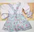 Conjunto Bata ou Body Menina Branca Bufante com Laço Catherine Floral Saia de Pregas Jardineira e Laço Catherine Floral Índigo Trend - comprar online