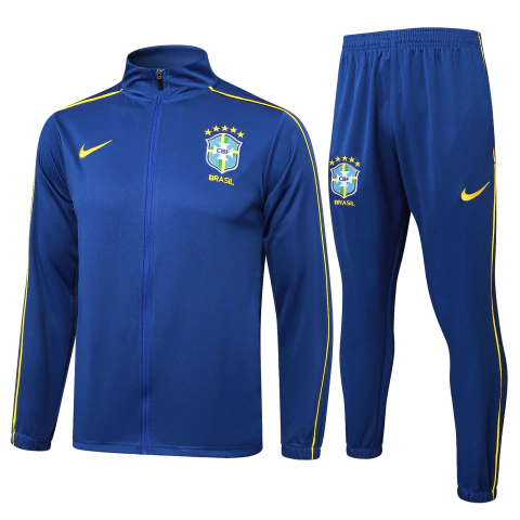 Conjunto de treino Brasil 24/25 da Nike azul, composto por jaqueta e calça azul com detalhes em amarelo e emblema da Seleção Brasileira.