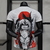 Camisa branca com detalhes em preto e vermelho, apresentando a arte de Itachi Uchiha, personagem do anime Naruto, na parte de trás.