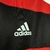 vista do escudo da adidas da camisa retrô do Flamengo Icon 2018 retrô, com listras vermelhas e pretas, modelo masculino.