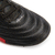 Detalle de un botín Joma Aguila para hombre, con diseño en cuero negro y detalles en rojo.
