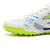 Botines Joma Liga 5 para hombre, de color blanco con detalles en verde y azul, ideales para fútbol 5.