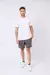 Camiseta blanca de hombre Snauwaert Arman, combinada con pantalones cortos grises y zapatillas blancas.