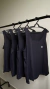 camisetas fitness em dry fit preto em uma arara em um ambiente interno.