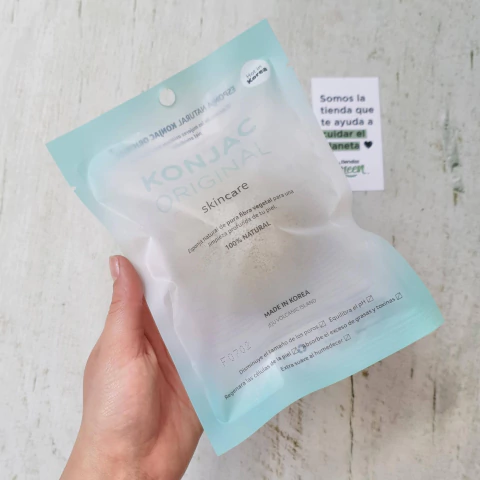 Esponja Konjac Facial con Arcilla Verde en su empaque, sostenida por una mano.