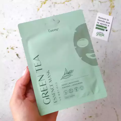 Mascarilla facial de té verde de la marca Coony, en envase verde con ilustraciones y texto que destaca sus beneficios de desinflamar, iluminar, purificar e hidratar la piel.
