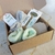 Combo de regalo de Navidad con productos de skincare, incluyendo un masajeador de piedra jade, esponjas y un lazo suave en una caja marrón.