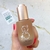 Frasco del Serum Facial y Contorno de Ojos Reafirmante Botxlike de BEK, sostenido en una mano con uñas pintadas de rojo.