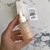 Frasco de serum facial revitalizante Energy de BEK, con gotero, en una mano. Fondo con caja del producto y nota sobre sostenibilidad.