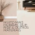 Rodapé de poliestireno branco de 15cm em um ambiente moderno com sofá cinza e decoração minimalista.