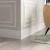Rodapé de poliestireno liso branco de 20cm de altura instalado em ambiente residencial com piso de madeira.