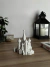 Miniatura de la Catedral de San Basilio en color blanco, ubicada sobre una mesa de madera, junto a una planta y una lámpara.