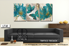 Tríptico decorativo LT41 con flores y mariposas en tonos aqua sobre fondo neutro, colocado en una sala moderna con sofá negro.