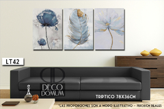 Tríptico decorativo LT42 con flores y plumas en tonos celestes, exhibido sobre un sofá negro.