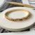 BRACELETE DOURADO ONDULADO COM ZIRCÔNIAS