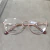 oculos de grau feminino marca morena rosa foto real da armação numa bandeja mostrando detalhes do aro em cor bronze, armação de metal delicada muito bonita
