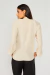 Modelo vestindo a Blusa Serena Creme vista de costas, com mangas longas e tecido leve, combinada com calça preta.