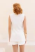 Modelo usando colete de linho off white visto de costas.